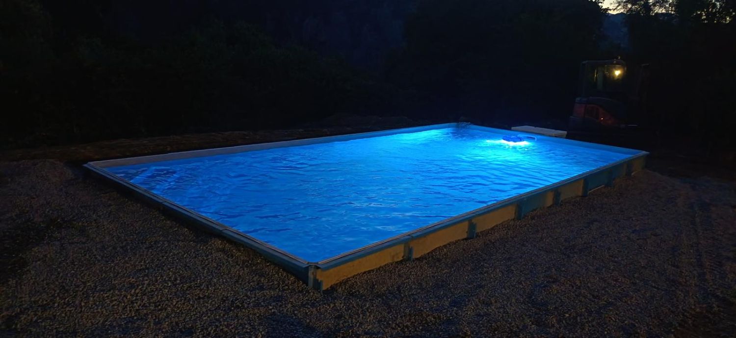 DP Piscine — le bassin éclairé en soirée